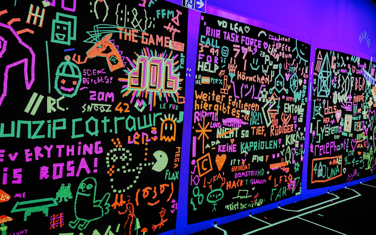 A wall decorated with colourful writings.