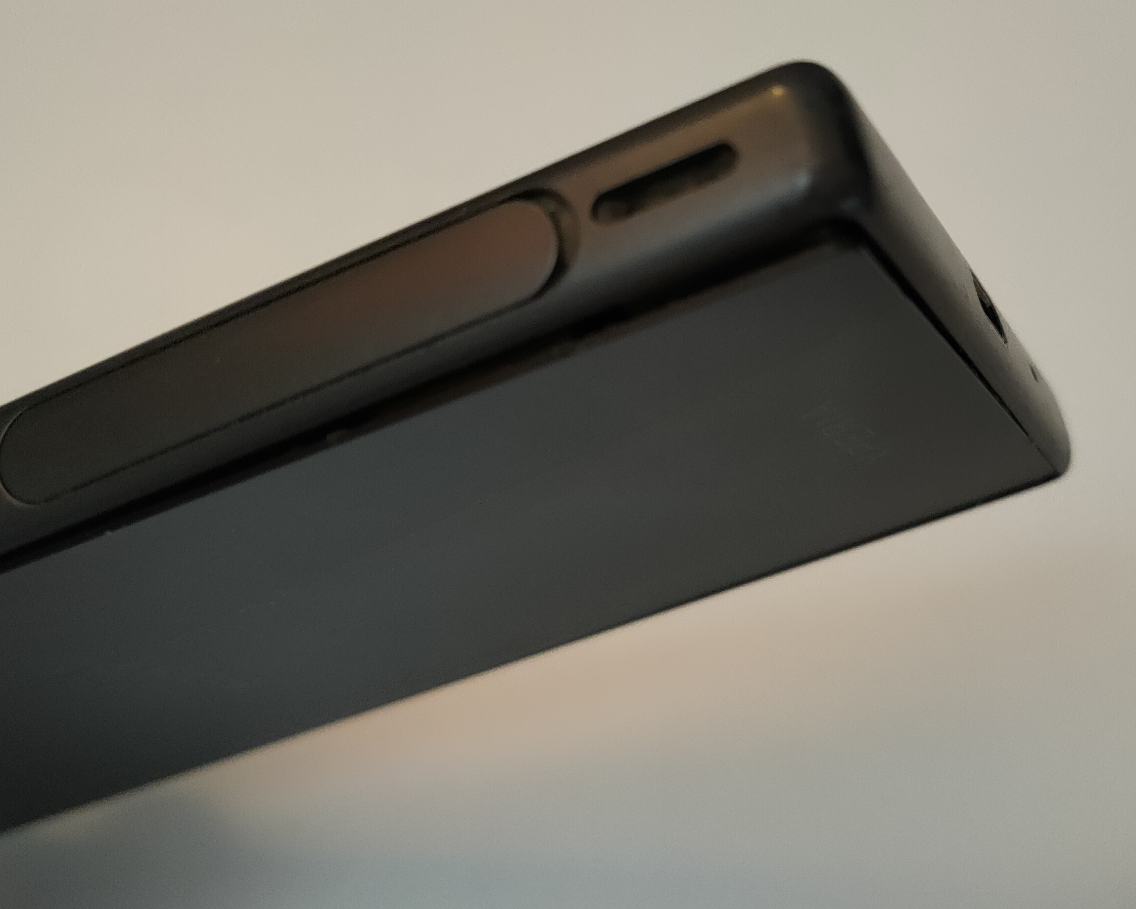 Plaque arrière de mon Xperia Z5 compact qui dépasse, à côté de la prise micro-usb